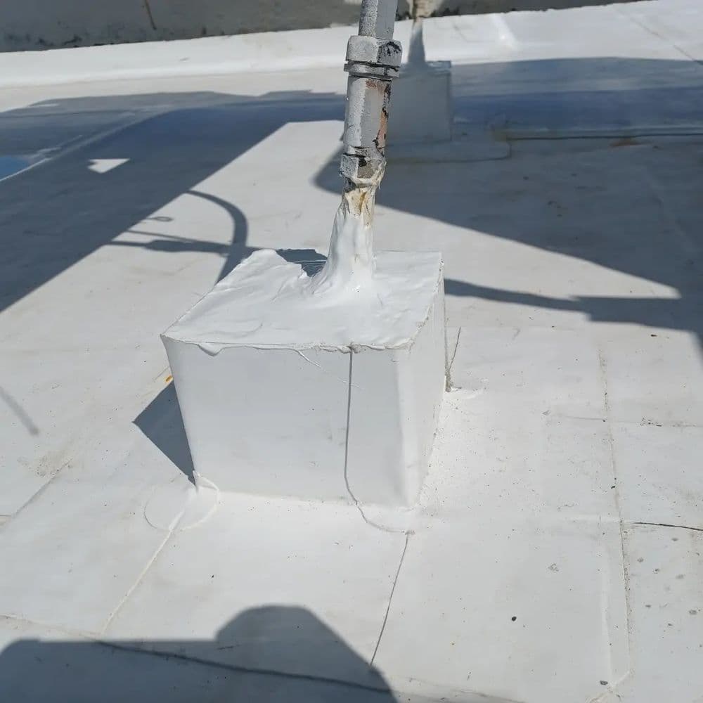 White waterproof sealant application on a roof structure for protection against leaks.