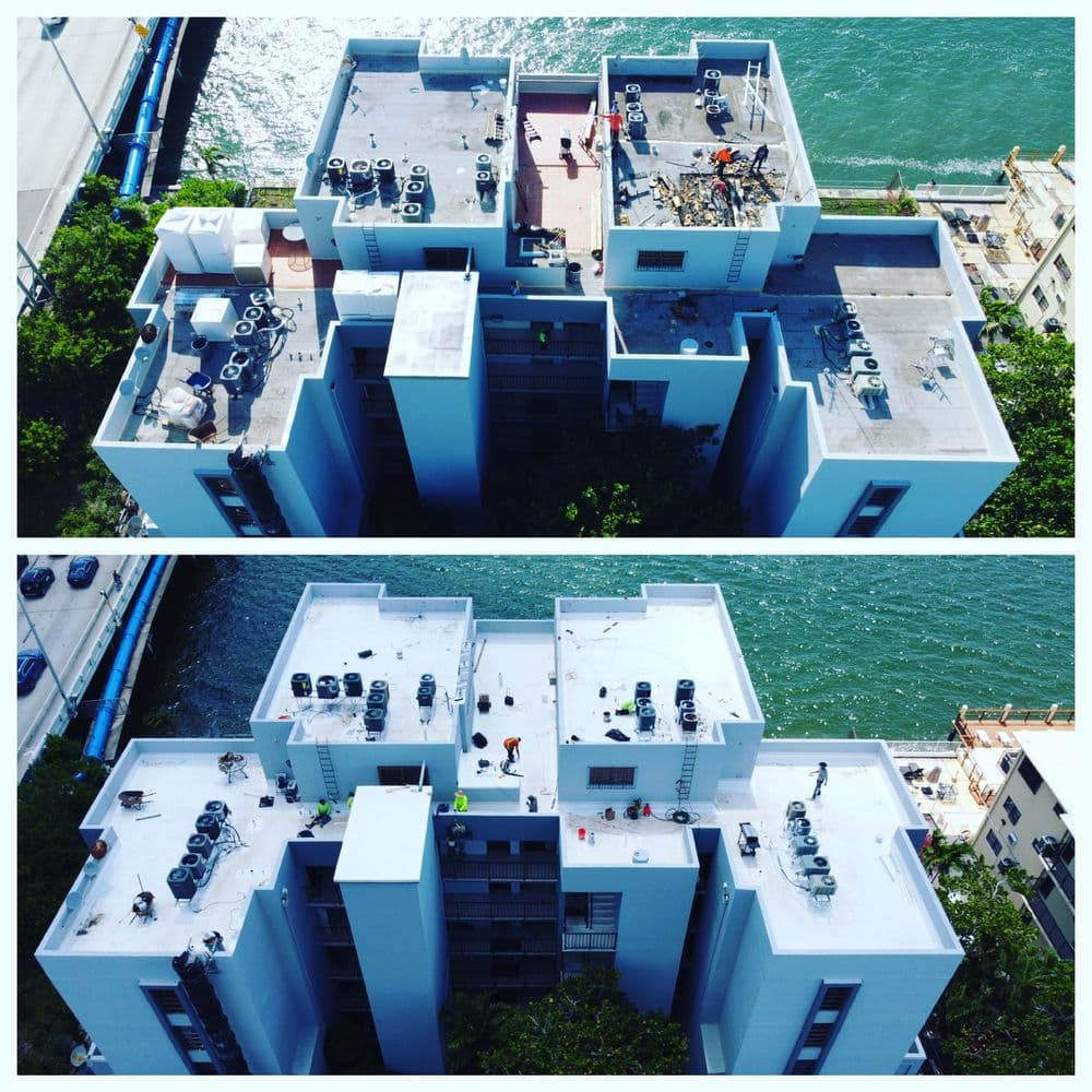 Aerial view of rooftop renovations with workers on a waterfront building.